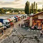Restaurant routier avec camions stationnés et route endommagée.