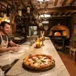 Chef prépare pizza artisanale dans restaurant rustique avec four à bois