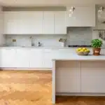 Cuisine blanche et marbre avec îlot central et baies vitrées