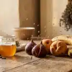 Fruits frais, miel doré et lavande séchée sur bois rustique